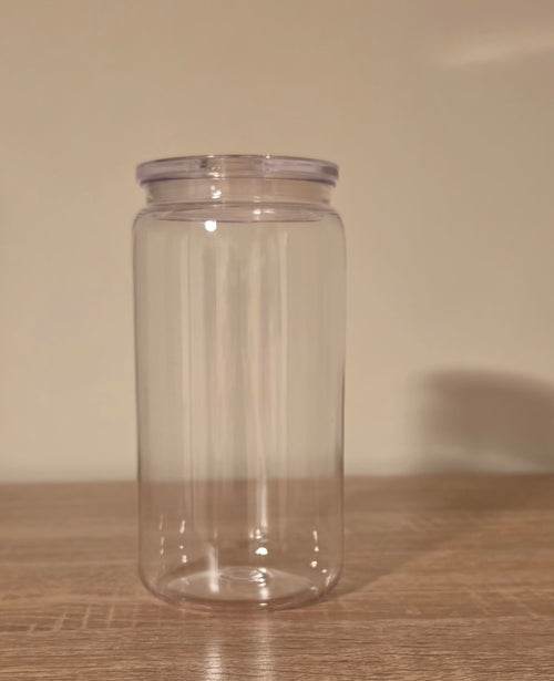 A clear plastic storage jar with a screw-on lid, standing on a wooden surface against a plain beige wall.
BH Creations by mel