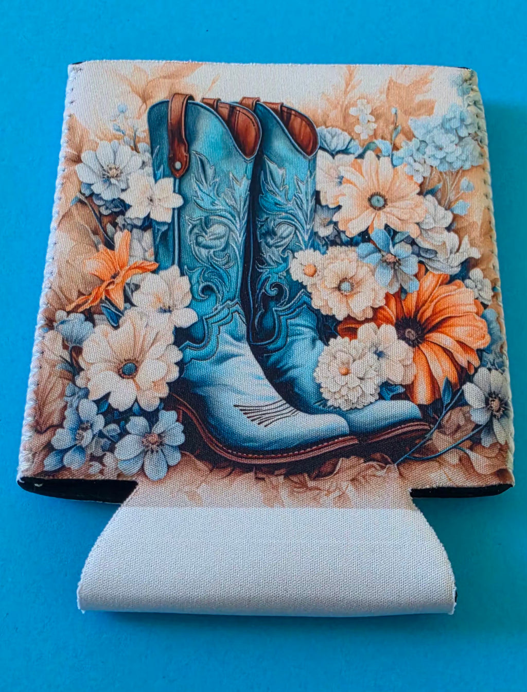 Decorative Stubby Holder with blue cowboy boots and flowers on a blue background. 
Homemade- BH Creations By Mel