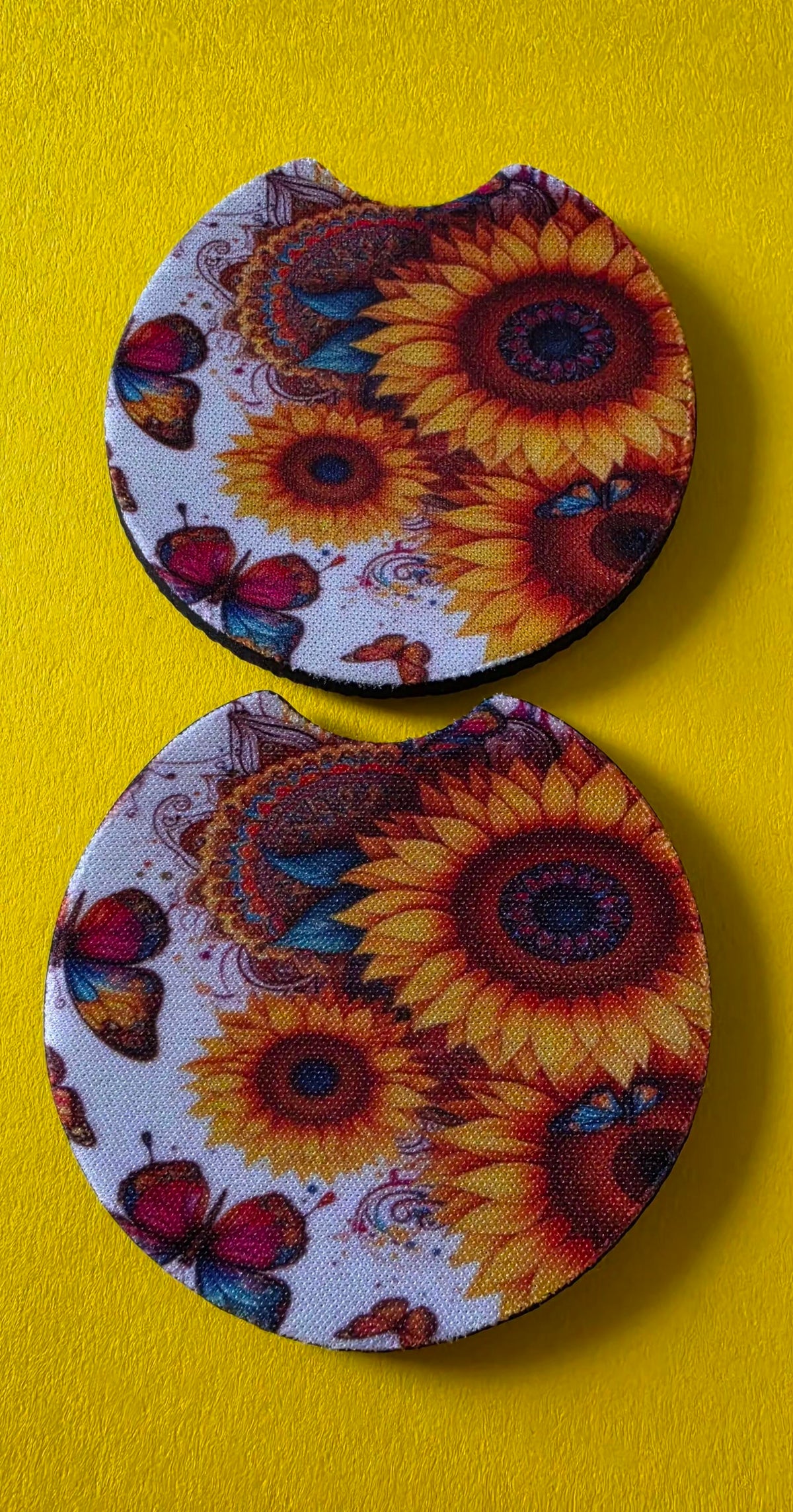 Two round car coasters with sunflower and butterfly design on a yellow background.
Homemade - BH Creations By Mel